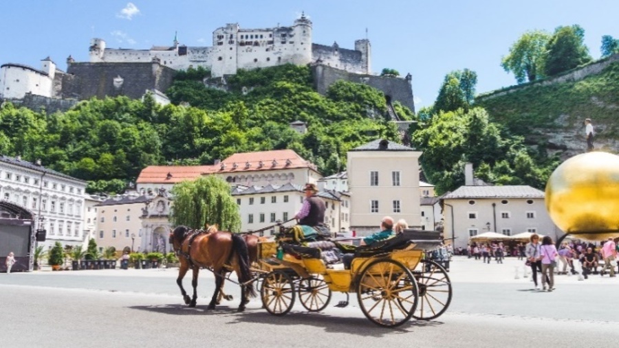 Tourists on a sightseeing tour by horse-drawn carriage in Salzburg