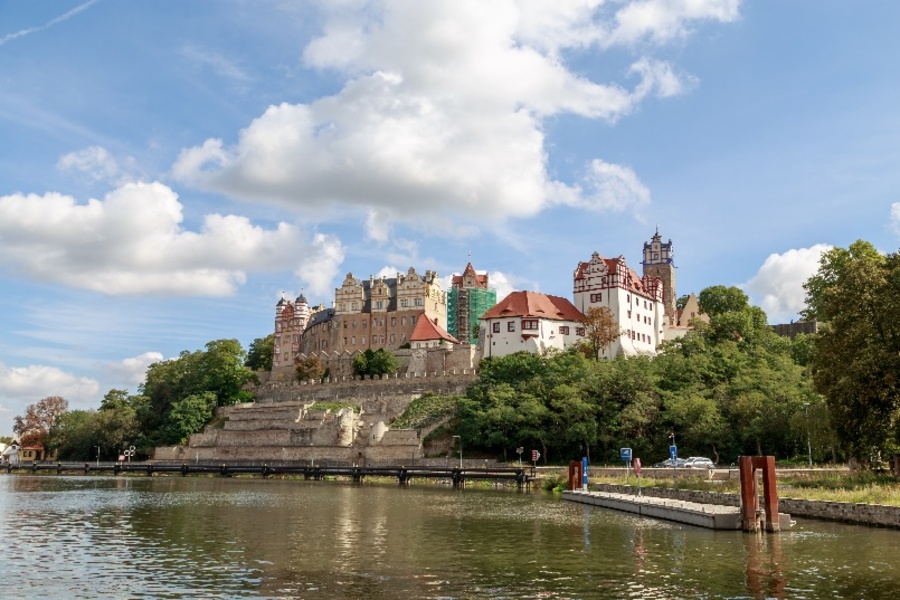 Schloss Bernburg auf einer Anhöhe, im Vordergrund die Saale