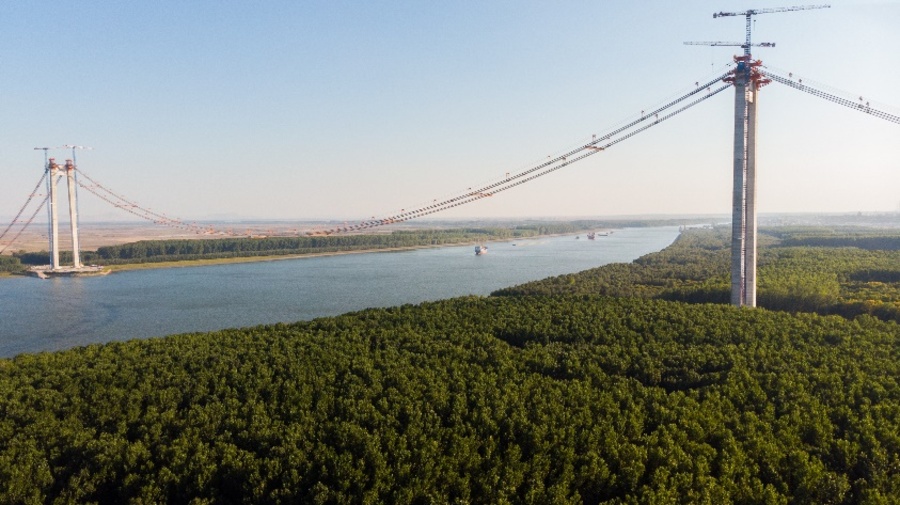 Panoramic aerial drone view of the suspended bridge over Danube river, under construction, between Braila and Tulcea cities