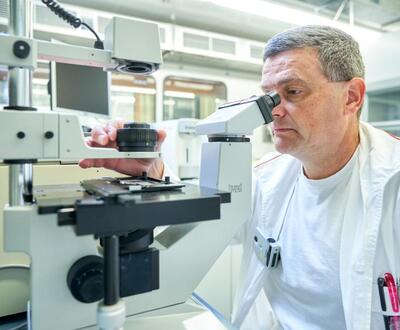 Mikroszkópjába néző kutató egy laboratóriumban